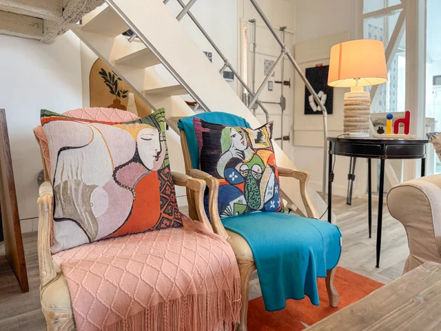 Armchairs with Picasso-print cushions in pink and teal